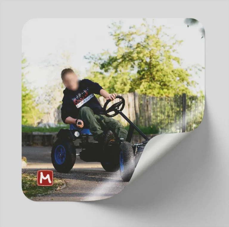 Aufkleber Kind fährt mit Kettcar um ein Eck