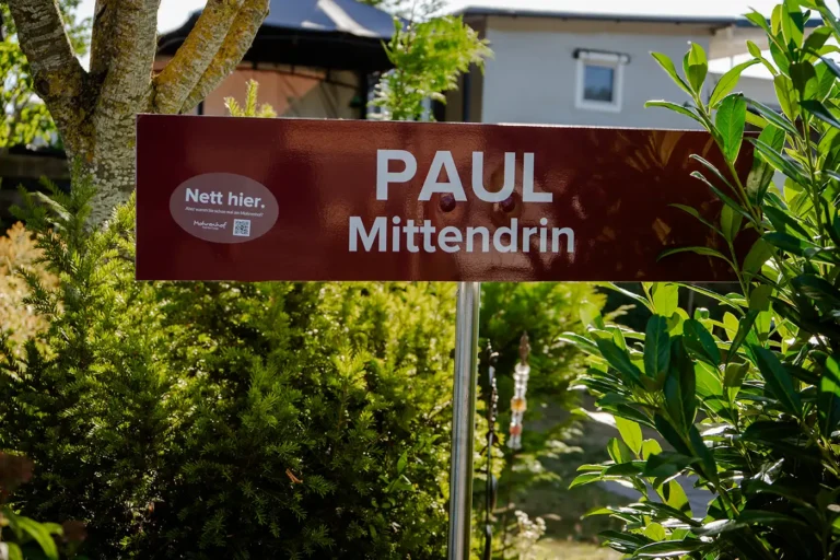 Rotes Straßenschild Paul Mittendrin im Grünbereich des Campingplatzes