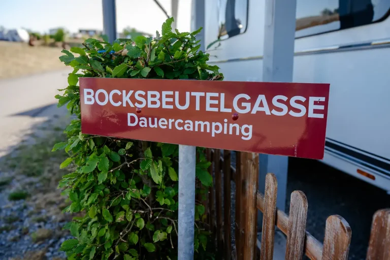 Rotes Straßenschild Bocksbeutelgasse Dauercamping am Campingplatz
