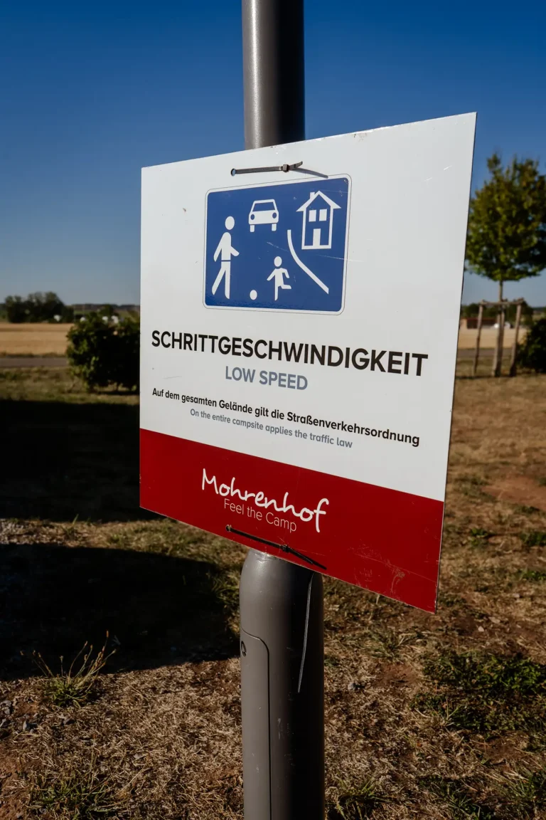 Hinweisschild Schrittgeschwindigkeit mit Symbol für verkehrsberuhigten Bereich auf dem Campingplatz