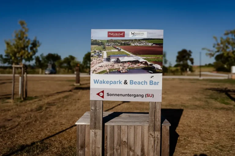 Hinweisschild mit Wegweiser zum Wakepark, der Beach Bar und dem Bereich Sonnenuntergang