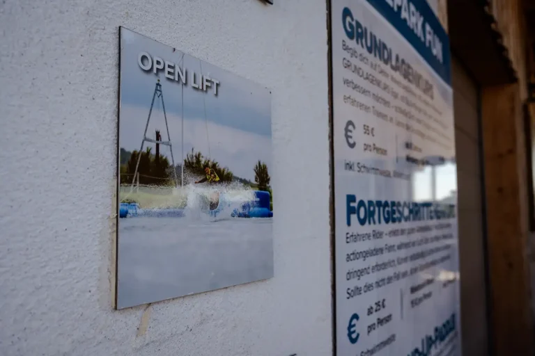 Informationsschild für den Open Lift Wakeboard-Kurs an der Hauswand
