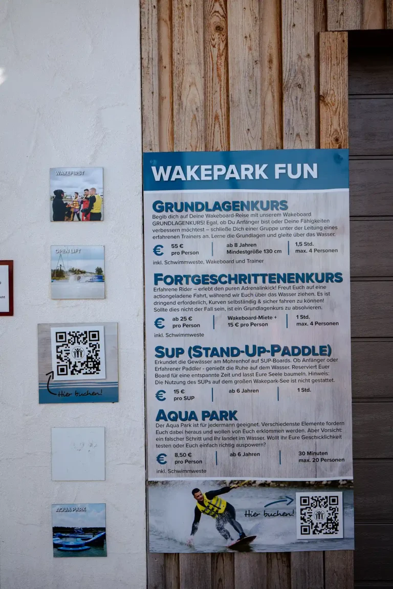 Übersichtstafel für Wakepark-Kurse, SUP-Verleih und Aquapark mit Preisen und QR-Codes