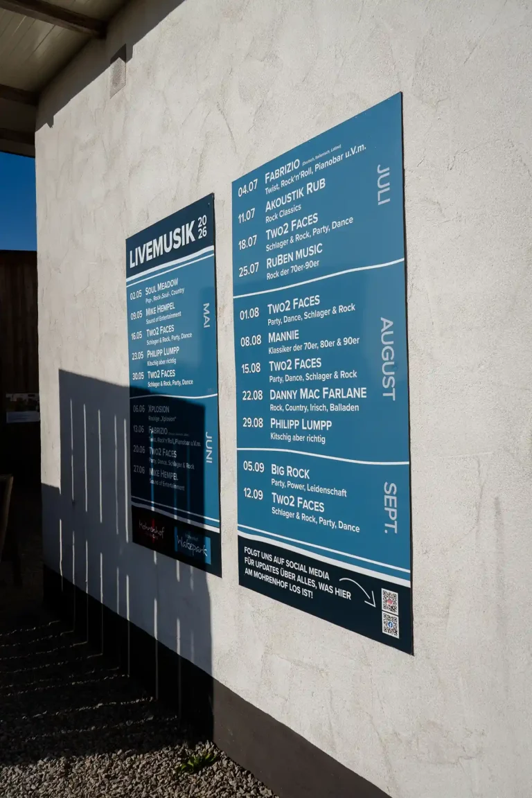 Aushang-Tafel mit der Programmübersicht für Livemusik an der Hauswand